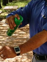 Person spraying mosquito spray on their arm